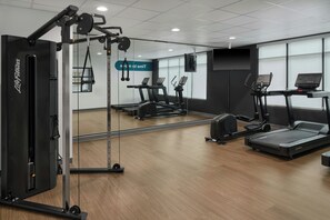 A gym with cardio machines, weight training equipment, and a mirrored wall. - StudioRes by Marriott Wilmington (Wilmington)