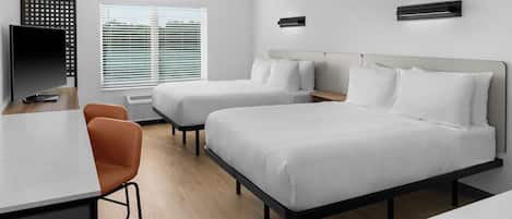 A modern hotel room with two beds, a desk, and a chair.