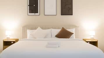 A hotel room with a bed, two bedside tables with lamps, and three framed pictures on the wall.