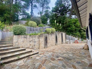 Eine Steintreppe führt zu einer Steinmauer mit einem hölzernen Zaun.