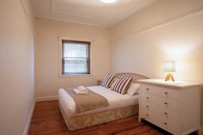 A bedroom with a bed, bedside table, lamp, window, and wooden flooring. - Stylish 1BR Vaucluse Escape | Near Shops & CBD (Vaucluse)