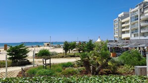 Ein Küstenhotel mit Strandblick, Außenbereich und einem modernen Gebäude mit Balkonen.