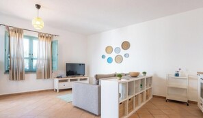 Ein modernes Wohnzimmer mit einer Couch, einem Fernseher und Stauraumeinheiten.