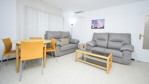 A living room with a grey sofa, a coffee table, a dining table with chairs, and a picture on the wall. - FLECHA (3 BEDROOMS) (Benidorm)