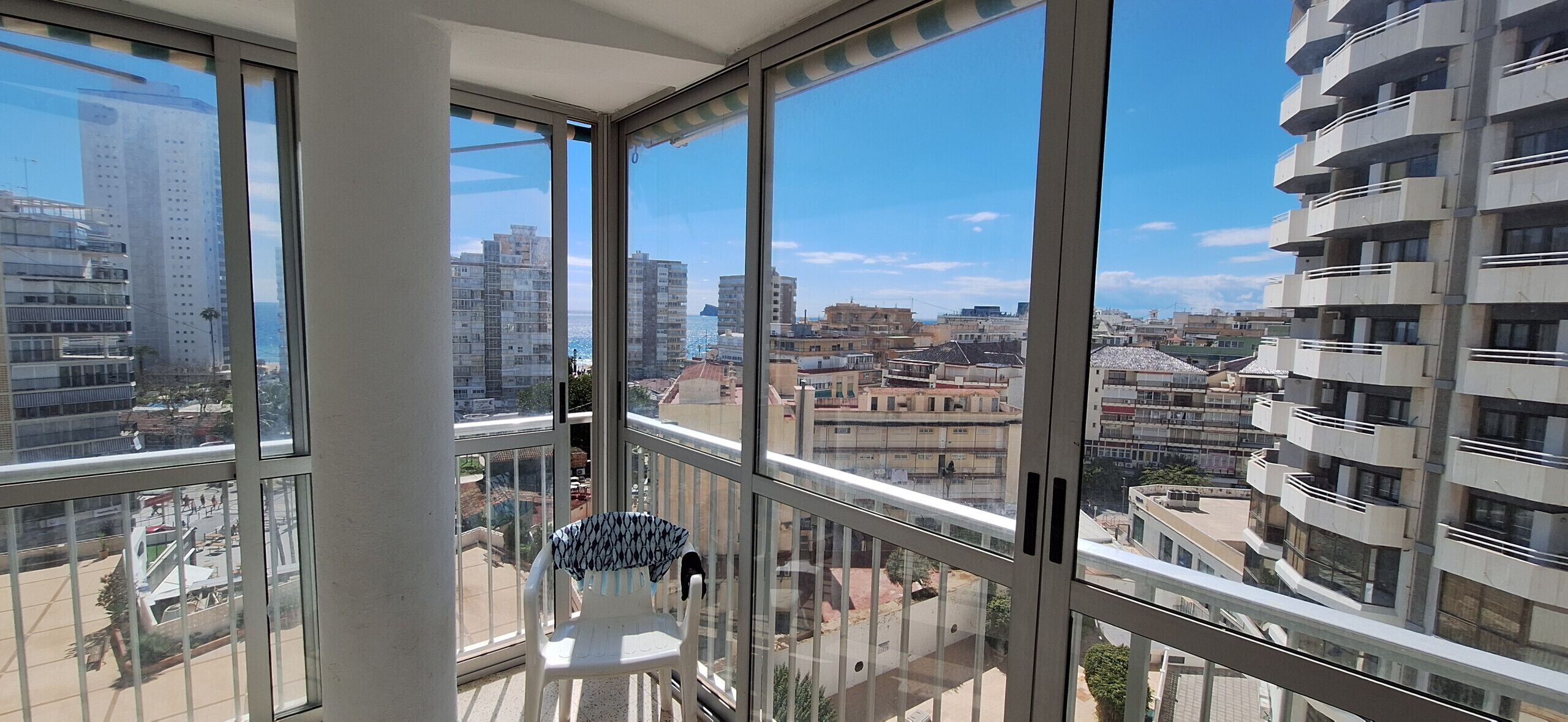 Un immeuble de grande hauteur doté de grandes fenêtres, d’un balcon et offrant une vue sur le paysage urbain.