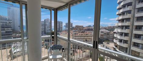 Un immeuble de grande hauteur doté de grandes fenêtres, d’un balcon et offrant une vue sur le paysage urbain.