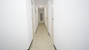 A narrow hallway with white walls and a speckled floor, leading to a door at the end. - FLECHA (3 BEDROOMS) (Benidorm)