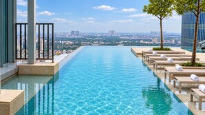 A rooftop infinity pool with a city view, lounge chairs, and a clear sky. - Shilla Monogram Hanoi Westlake Hotel (Hanoi)