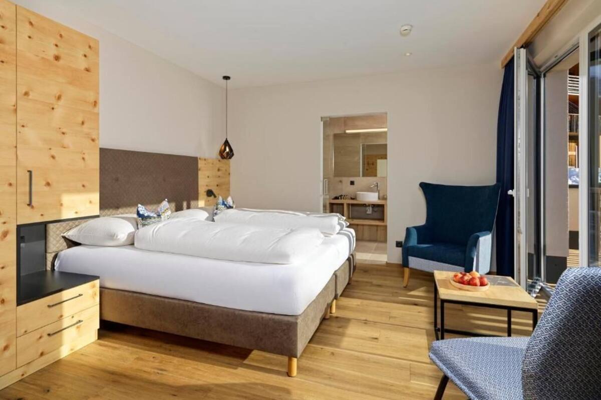 Un dormitorio moderno con una cama grande, muebles de madera, un escritorio y una silla.