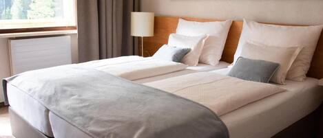 A double bed with a headboard, a bedside lamp, and a painting on the wall.