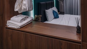 A modern bedroom with a wooden ceiling, a bed with white bedding, a painting on the wall, and a ceiling-mounted projector. - Bee Stay Apartment Huy Van (Hanoi)