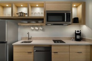 A modern kitchen with a built-in microwave, a coffee maker, and a dishwasher.