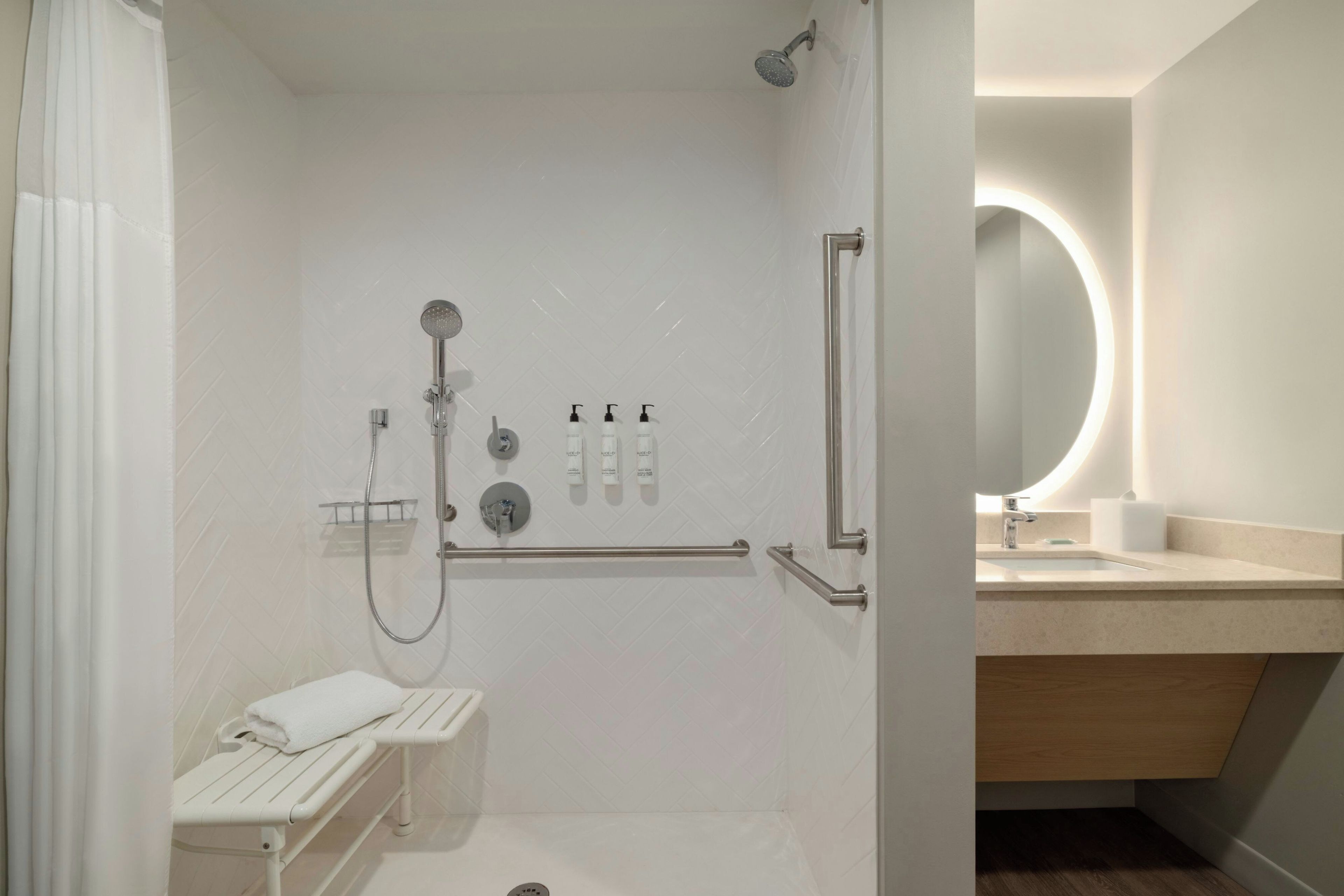 A modern bathroom with a shower, toilet, and sink.