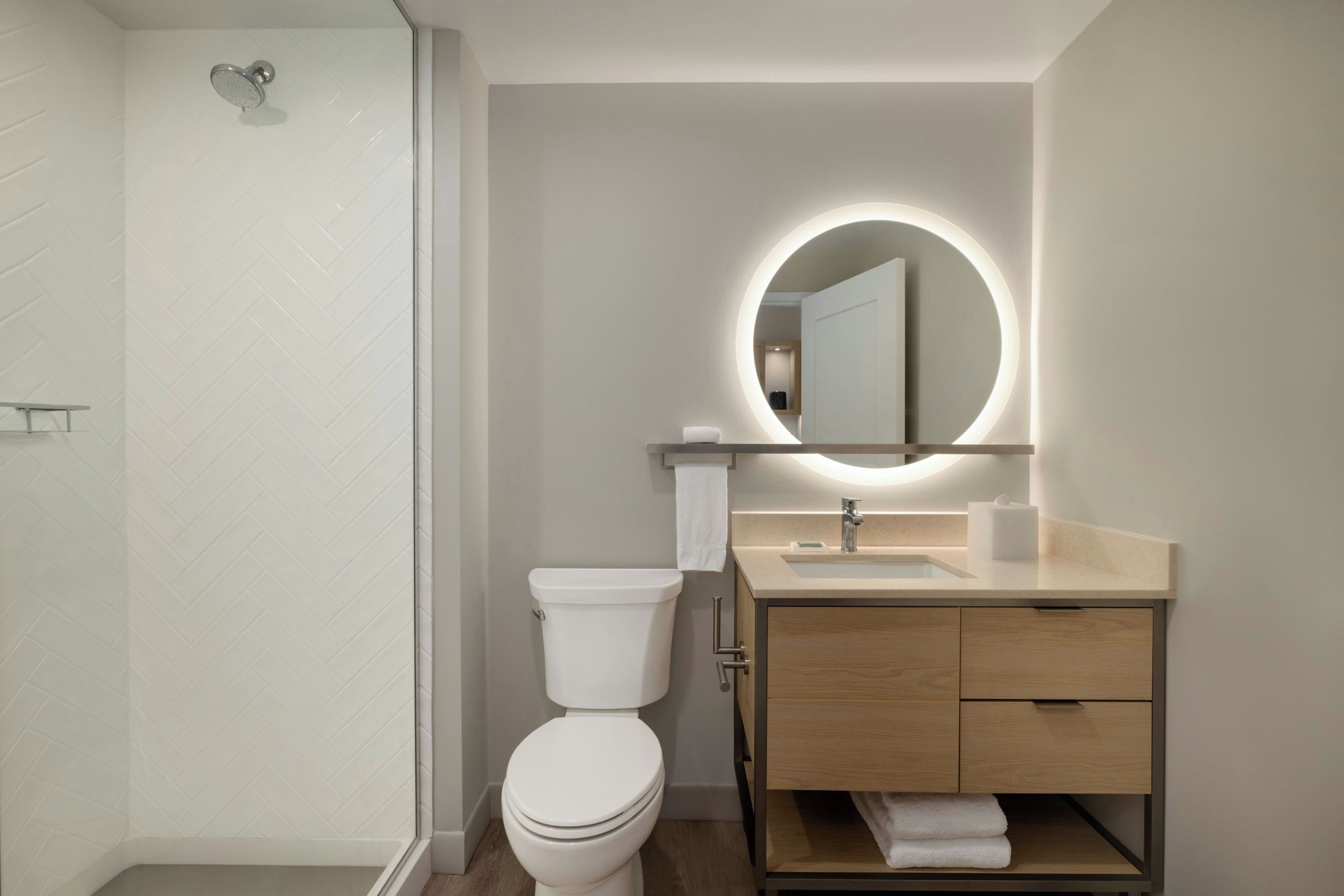 A modern bathroom with a toilet, sink, and shower.