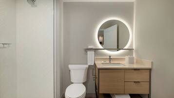 Une salle de bain moderne équipée de toilettes, d’un lavabo et d’une douche.
