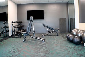 A gym with exercise equipment, a large mirror, and a television on the wall. - TownePlace Suites by Marriott Lebanon PA (Lebanon)