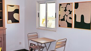 Una stanza con un tavolo e sedie, una finestra e un'opera d'arte astratta alle pareti.
