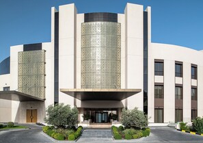 A modern building with a central entrance, large windows, and a patterned facade. - Ray Hotel by Cloud 7 (Mangaf)