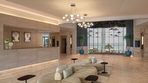 A modern lobby with a large seating area, a reception desk, and large windows with a view. - Ray Hotel by Cloud 7 (Mangaf)