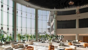 A spacious lobby with multiple seating areas, large windows, and indoor plants. - Ray Hotel by Cloud 7 (Mangaf)