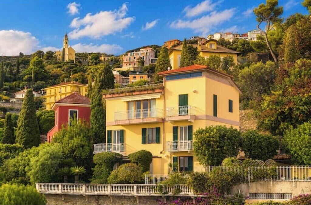 Una zona residenziale su una collina con un edificio giallo con balconi e un edificio rosso in primo piano.