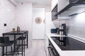 Eine moderne Küche mit schwarzem Arbeitsplatz, Edelstahlgeräten und einer Marmor-Spritzschutzwand.