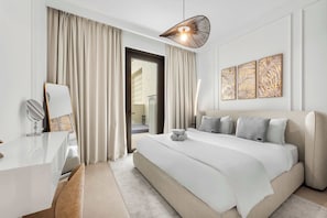Ein modernes Hotelzimmer mit einem großen Bett, einem Schreibtisch mit Spiegel und Blick auf den Außenbereich.