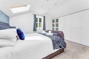 A bedroom with a bed, a window with curtains, a wardrobe, and a skylight. - Stylish Country Retreat-HotTub•Fire Pit•Games Barn (Helsby)