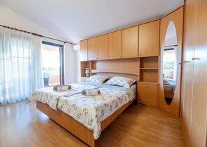 A bedroom with a wooden bed, a large mirror, and a view of the outdoors. - Holiday Home Tanja Vir with heated pool (Vir)