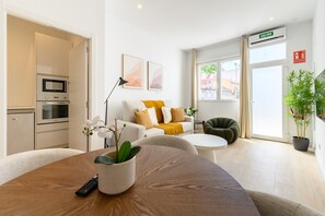 Ein modernes Wohnzimmer mit einer Couch, einem Couchtisch und einer Topfpflanze.