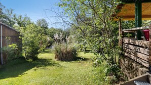 Ein Garten mit Holzzaun, einer Holzhütte und einer Rasenfläche.