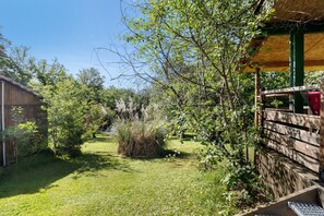 Ein Garten mit Holzzaun, einer Holzhütte und einer Rasenfläche.