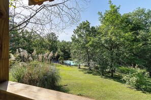 A view of a lush garden with a swimming pool, surrounded by trees and various plants. - Chalet 2 at Laupié near Sarlat (Proissans)