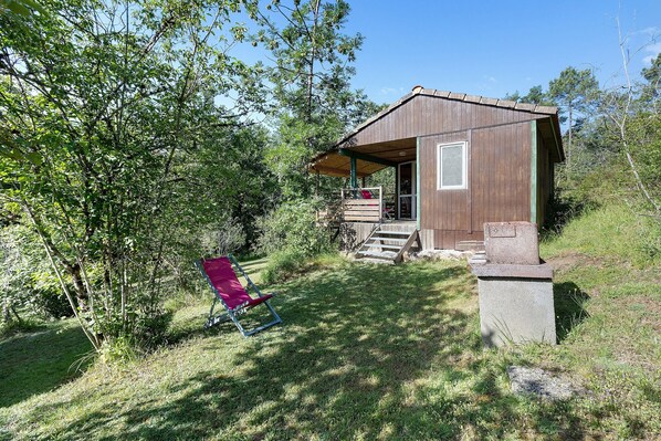 A rustic cabin with a porch, surrounded by trees and grass. - Chalet 2 at Laupié near Sarlat (Proissans)