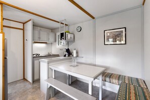 A compact kitchen with white cabinetry, a white countertop, and a bench. - Chalet 2 at Laupié near Sarlat (Proissans)