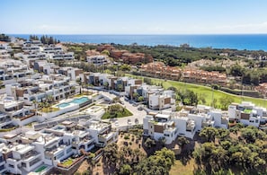 Ein Küstenwohngebiet mit moderner Architektur, einem Schwimmbad und einem Golfplatz.
