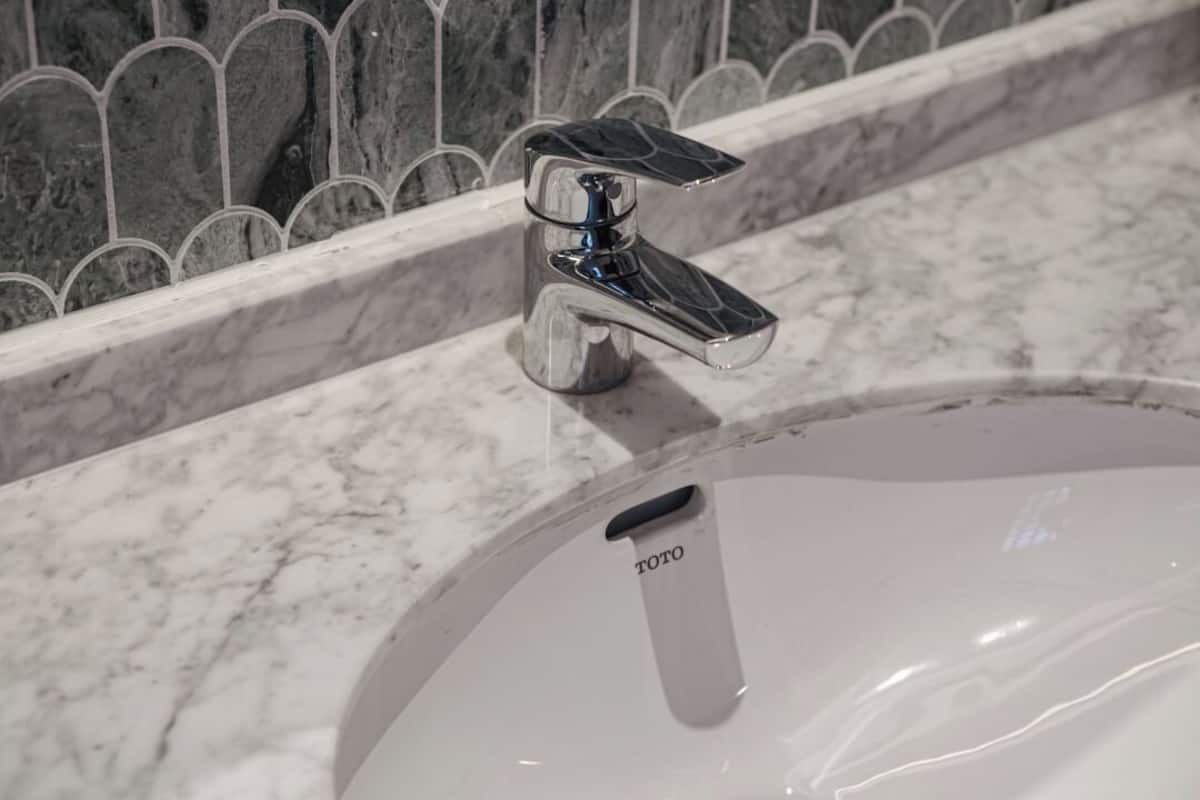 A bathroom sink with a chrome faucet and a white basin.