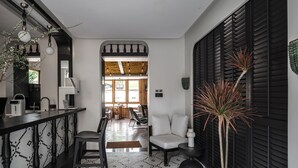 Una cocina moderna con barra, un área de comedor con vistas y un salón con una planta.