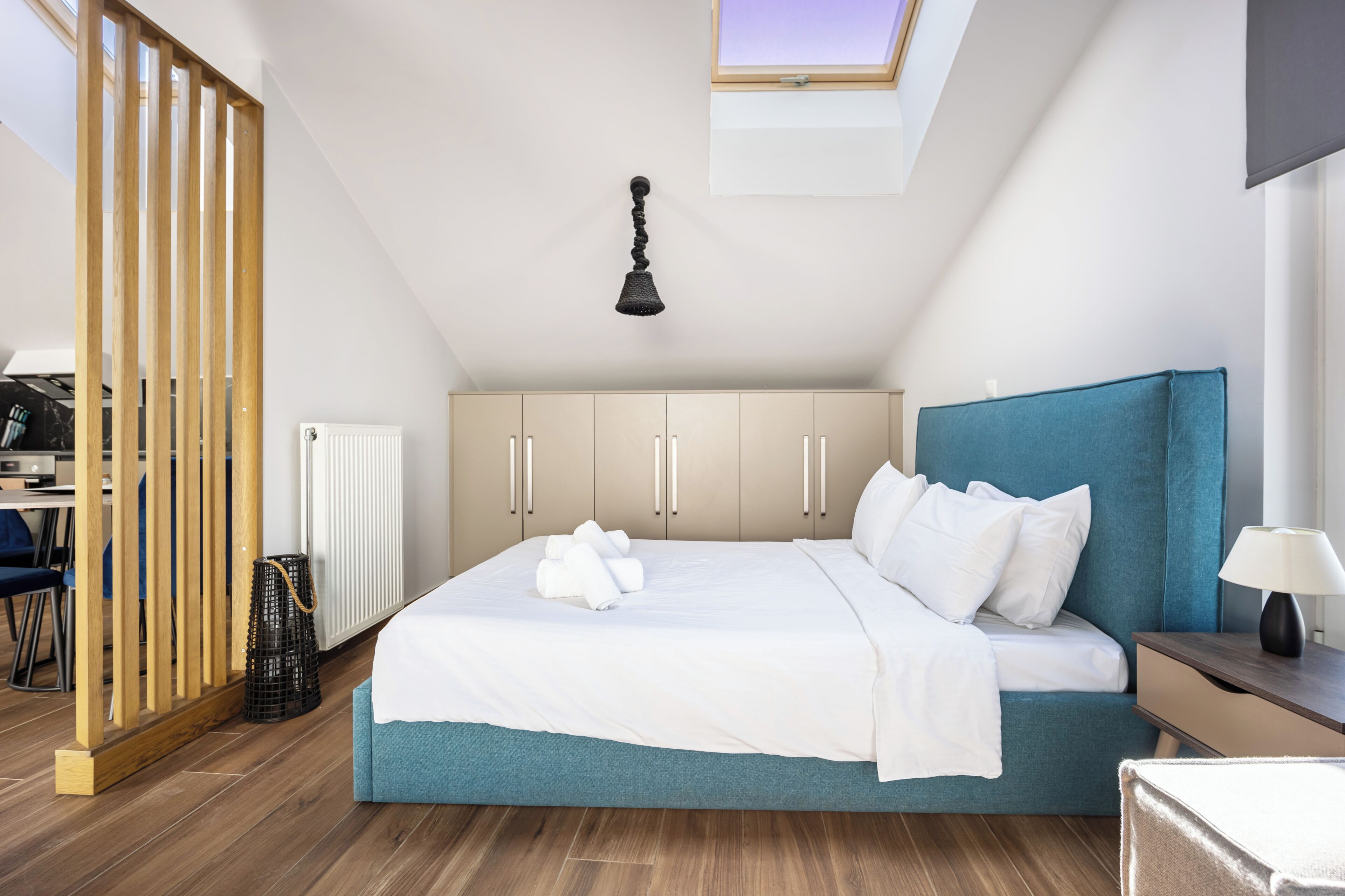 Une chambre à coucher comprenant un lit, un bureau, une chaise, un radiateur, un ventilateur de plafond et une fenêtre.