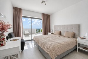 A bedroom with a large bed, a desk, and a view of the outdoors. - 3118 Luxury Penthouse with Panoramic Views (Casares)