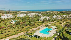 A resort with multiple white buildings, a large swimming pool, and palm trees. - 3118 Luxury Penthouse with Panoramic Views (Casares)