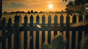 A sunset over a field with hay bales and a wooden fence. - Gorgeous and cosy 3-bedroom house in beautiful landscape. (Helsingborg)