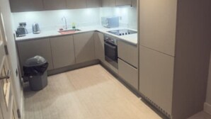 A compact kitchen with a microwave, coffee maker, and a small trash bin. - 1 Bedroom - Rubix (London)
