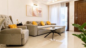 A modern living room with a sofa set, a coffee table, and a door. - FEMS | Luxury 3-Level Home w/ Private Jacuzzi (Nea Alikarnassos)