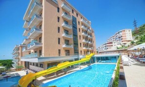 Una piscina techada, una piscina al aire libre de temporada, sombrillas