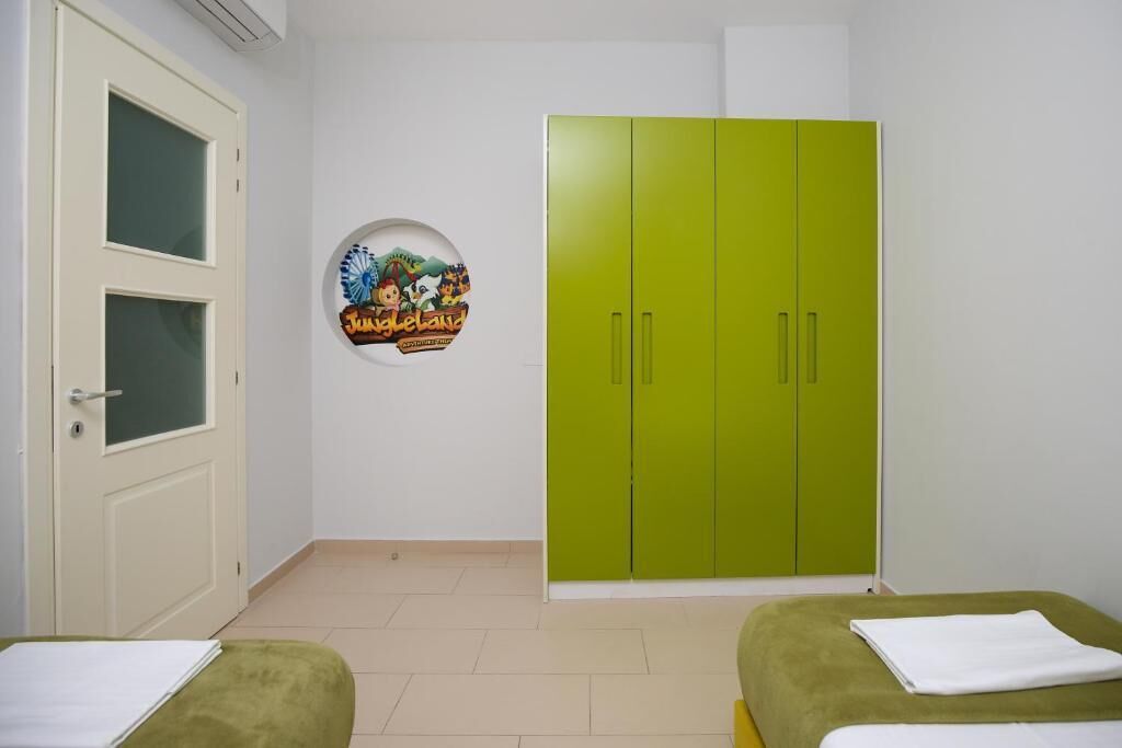 Une pièce avec une armoire verte, une porte à panneaux de verre et un élément décoratif circulaire sur le mur.
