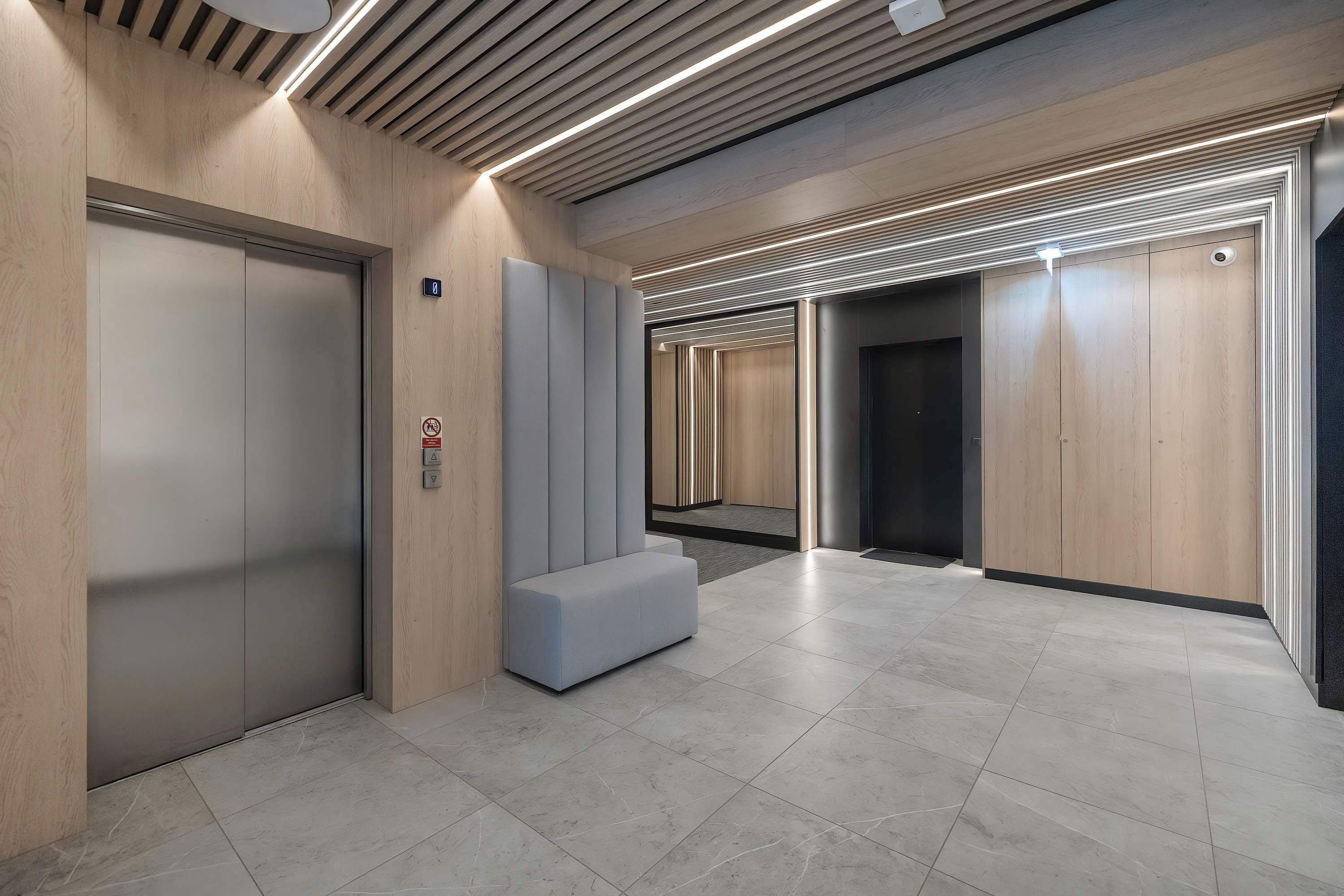 A modern indoor common area or hallway within the building. The finishes are simple, bright, and well-maintained.