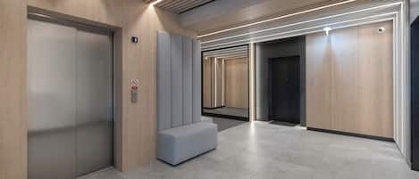 A modern indoor common area or hallway within the building. The finishes are simple, bright, and well-maintained.