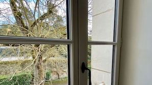 Una ventana con vistas a un árbol y una carretera.