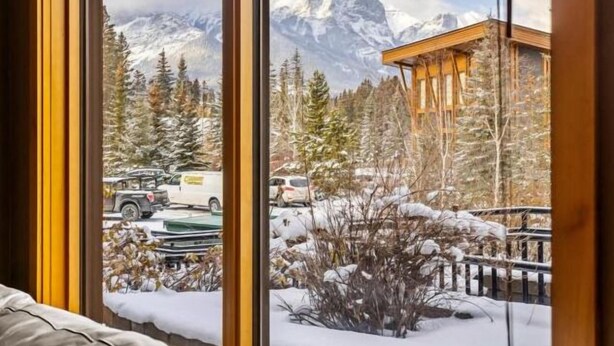 A mountain cabin with a view of snow-covered trees and mountains. - Spring Creek Courtyard Retreat | Hot Tub, Pool Table & Trailside Access (Canmore)